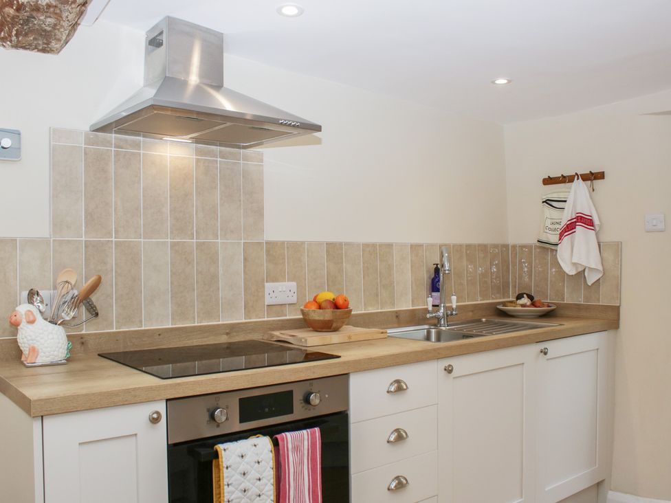 A kitchen with stovetop and sink at Upper Frogpool Cottage in Crediton