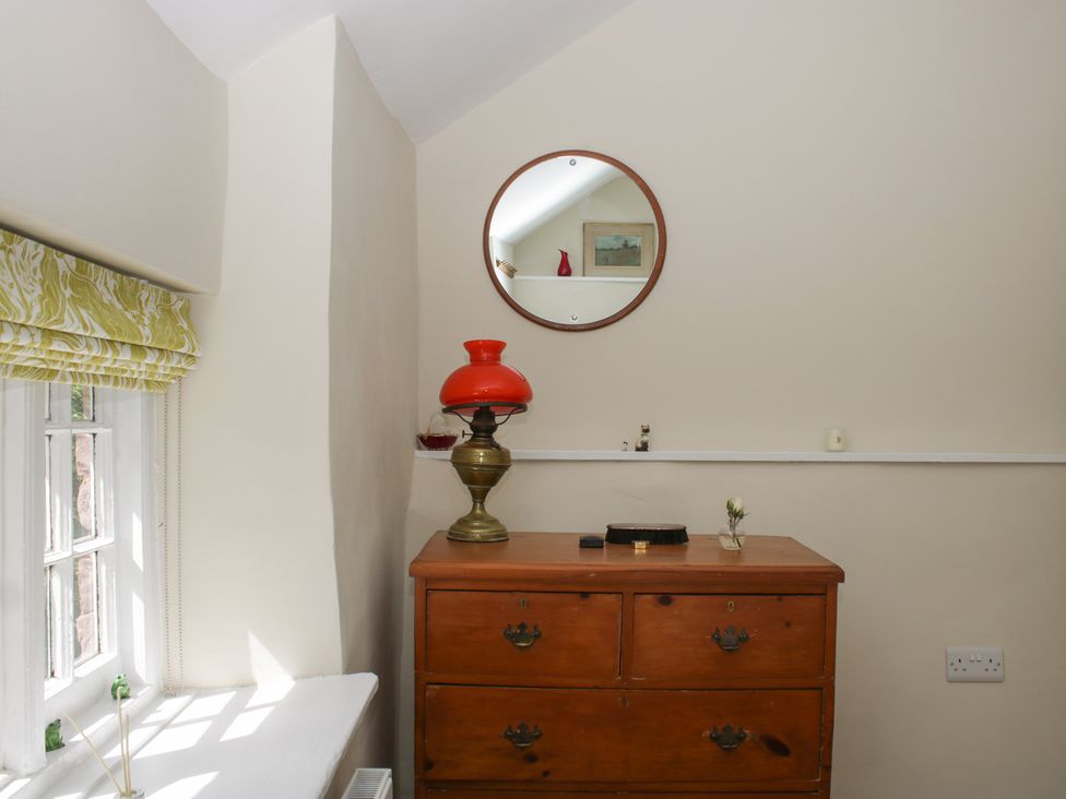 A room with a table and a lamp at Upper Frogpool Cottage Crediton