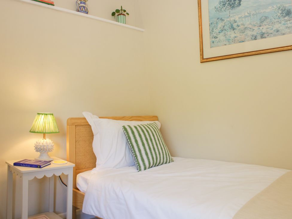 A bedroom with a bed and bedside table at Upper Frogpool Cottage in Crediton