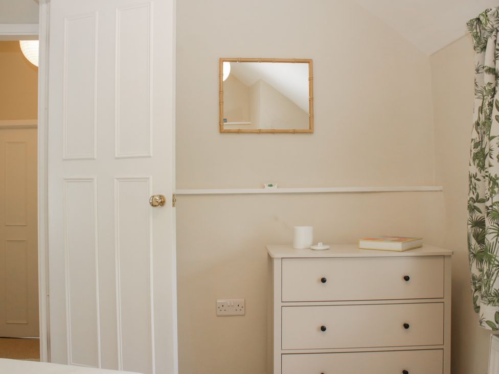 A bedroom with a mirror and chest of drawers at Upper Frogpool Cottage in Crediton