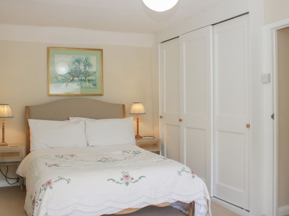 A bedroom with a bed and lamps at Upper Frogpool Cottage in Crediton