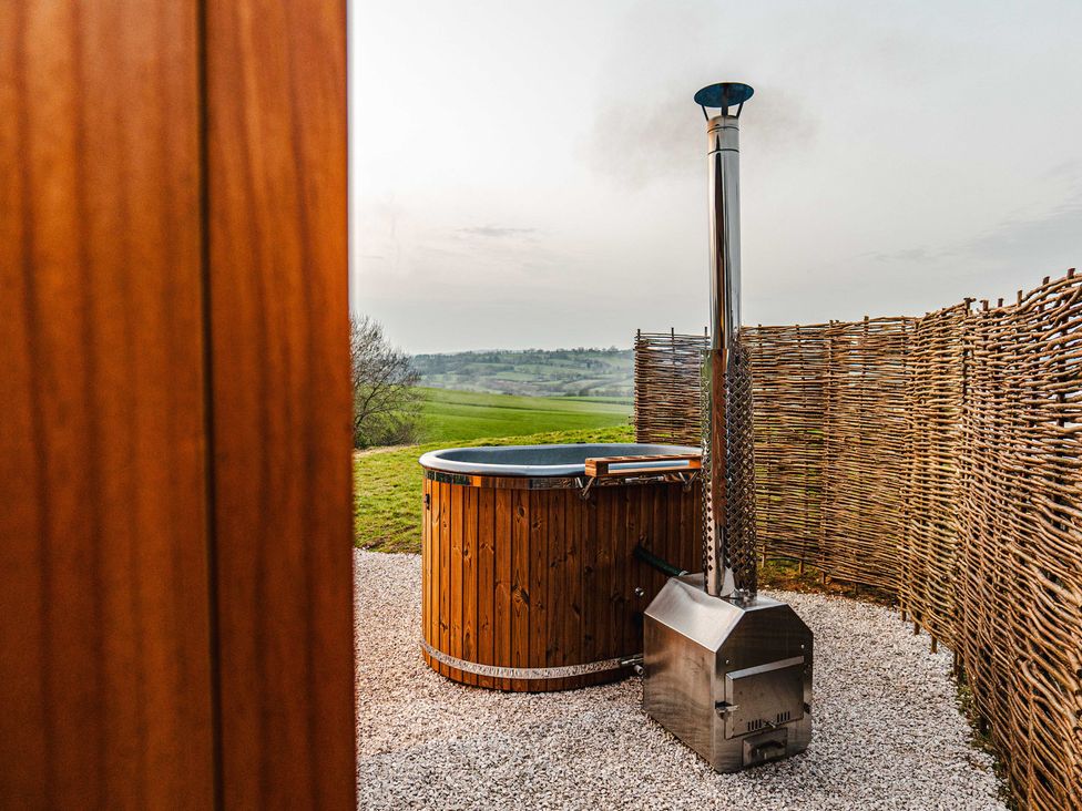 An outdoor area with a hot tub and chimney at Shepherds View in Bradley near Ashbourne