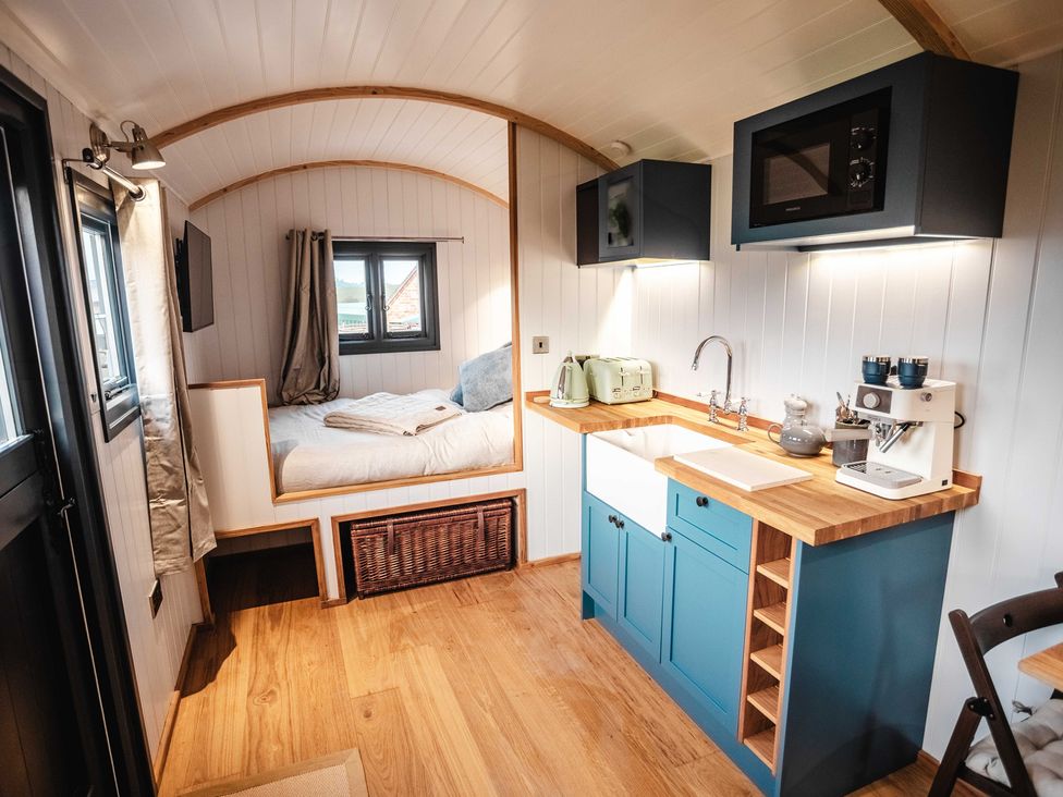 A tiny home interior with a kitchen and bed at Shepherds View in Bradley near Ashbourne