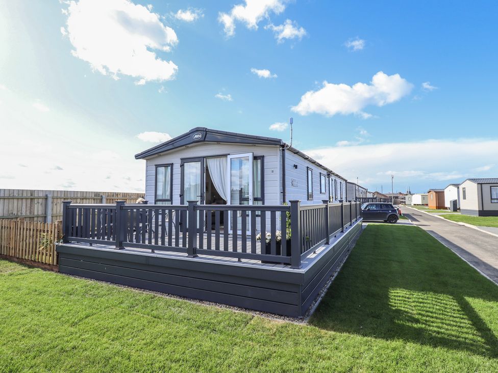 A mobile home with decking at Number 6 - Sandy Beach Holiday Park in Bacton