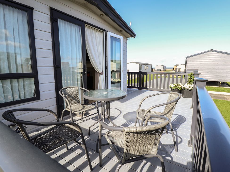 A deck with a table and chairs at Number 6 - Sandy Beach Holiday Park, Bacton