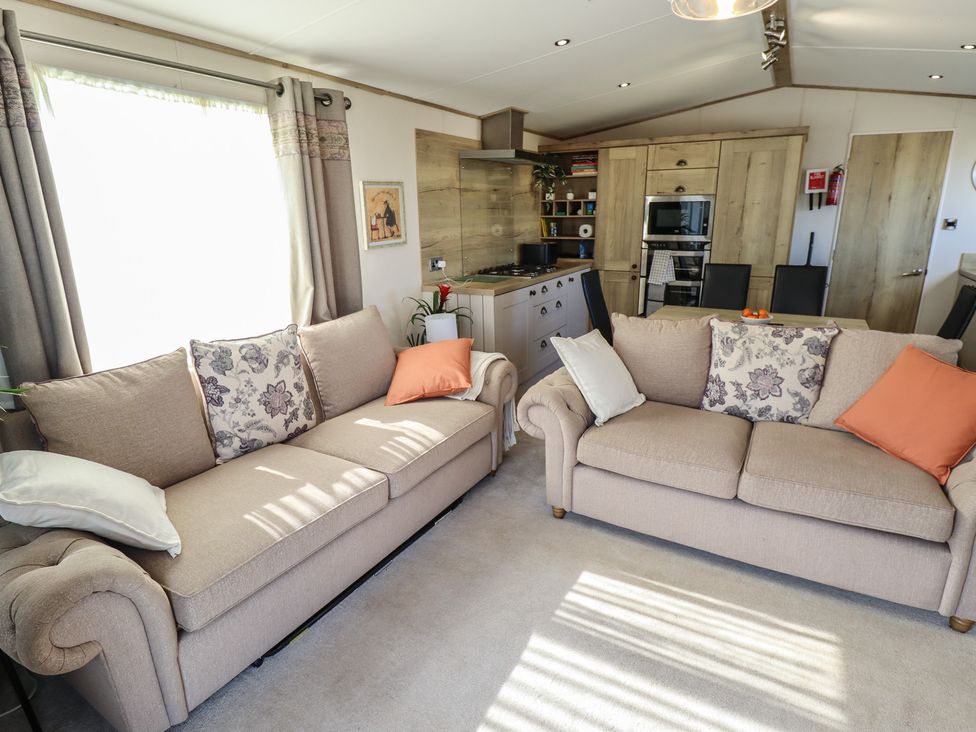 A living room with sofas and kitchen units at Number 6 - Sandy Beach Holiday Park in Bacton