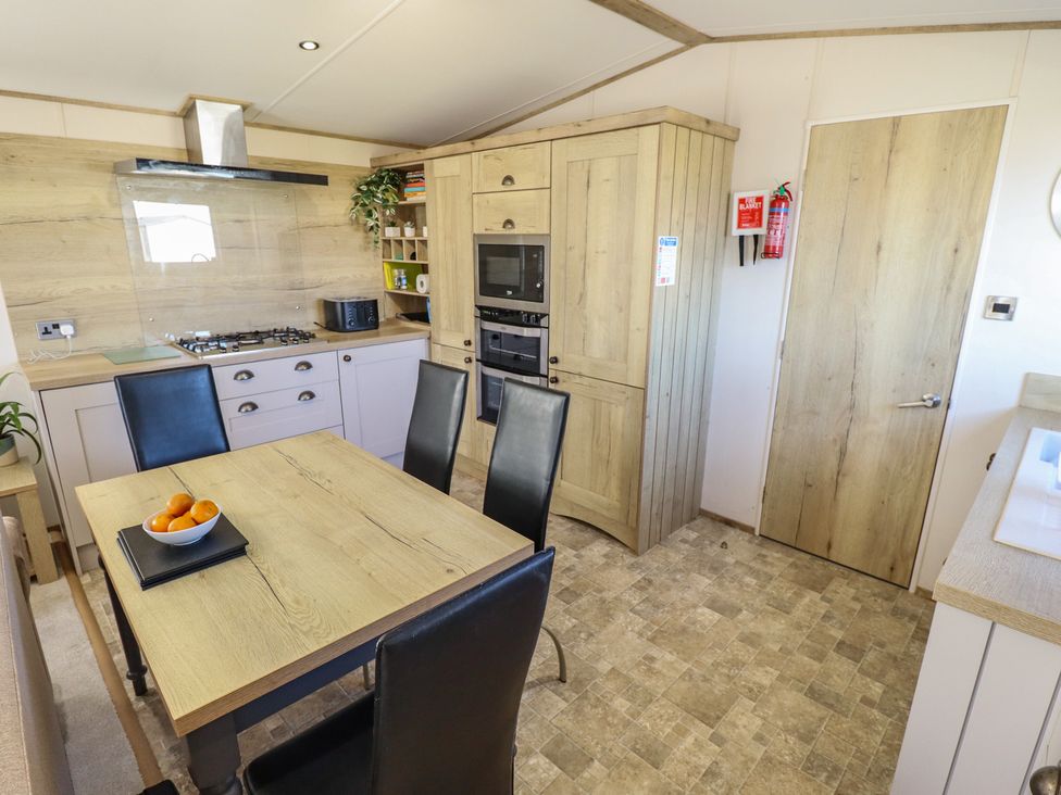 A kitchen with a table and chairs at Number 6 - Sandy Beach Holiday Park in Bacton