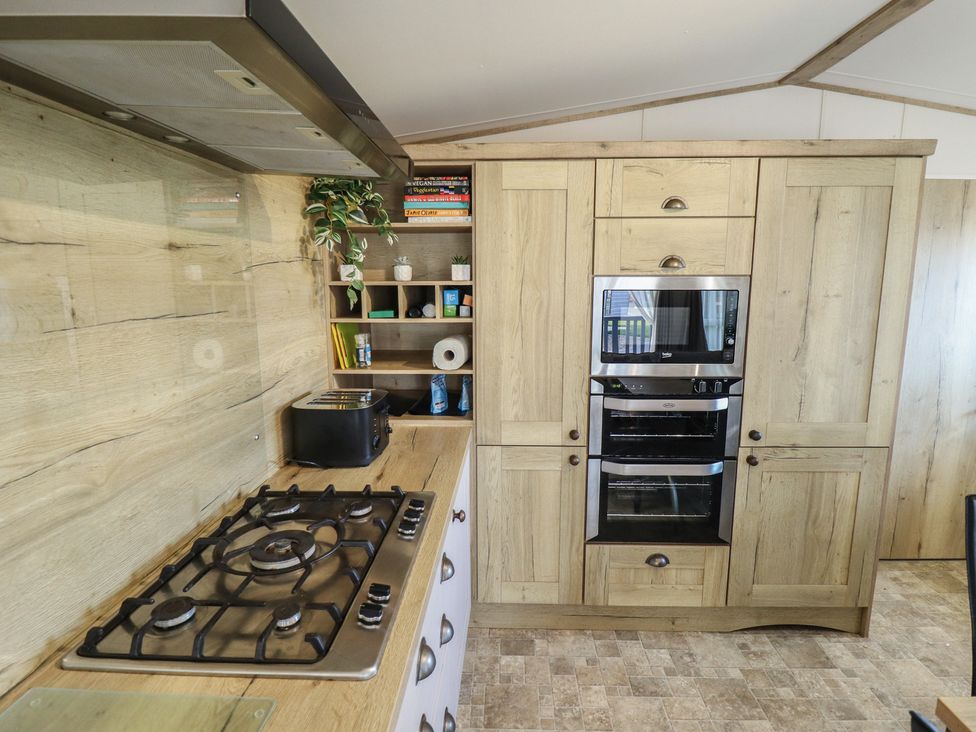 A kitchen with appliances and storage at Number 6 - Sandy Beach Holiday Park in Bacton