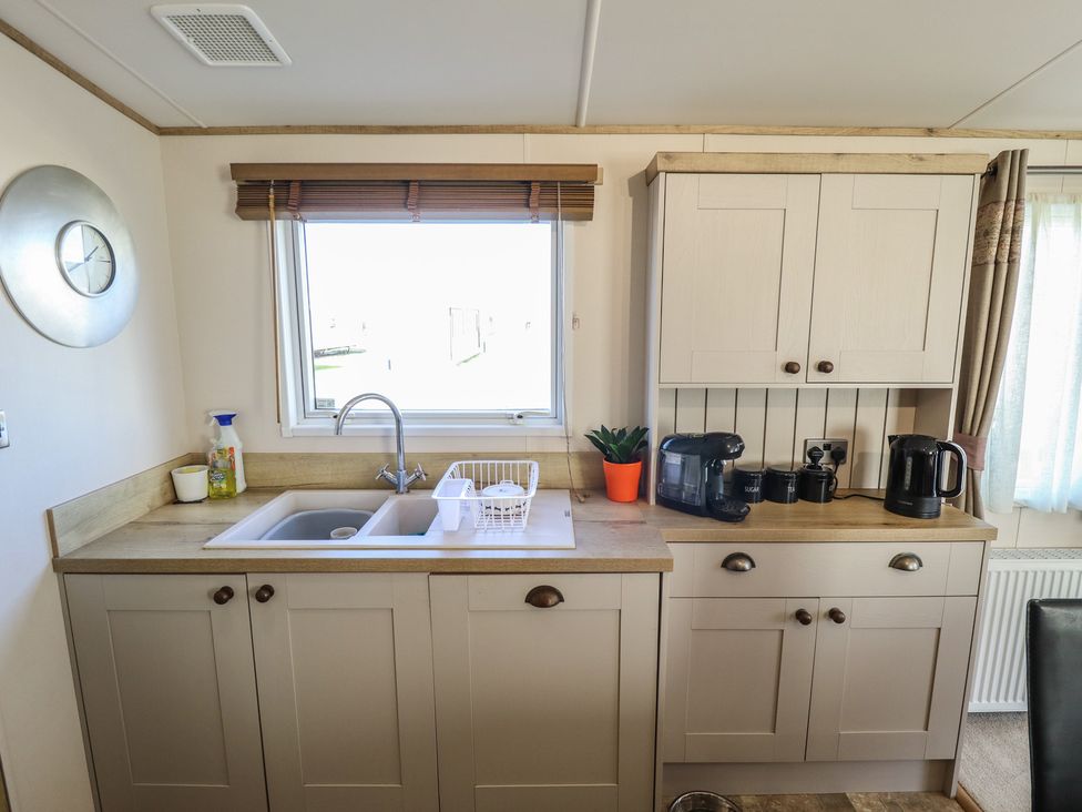 A kitchen with cabinets and sink at Number 6 - Sandy Beach Holiday Park Bacton