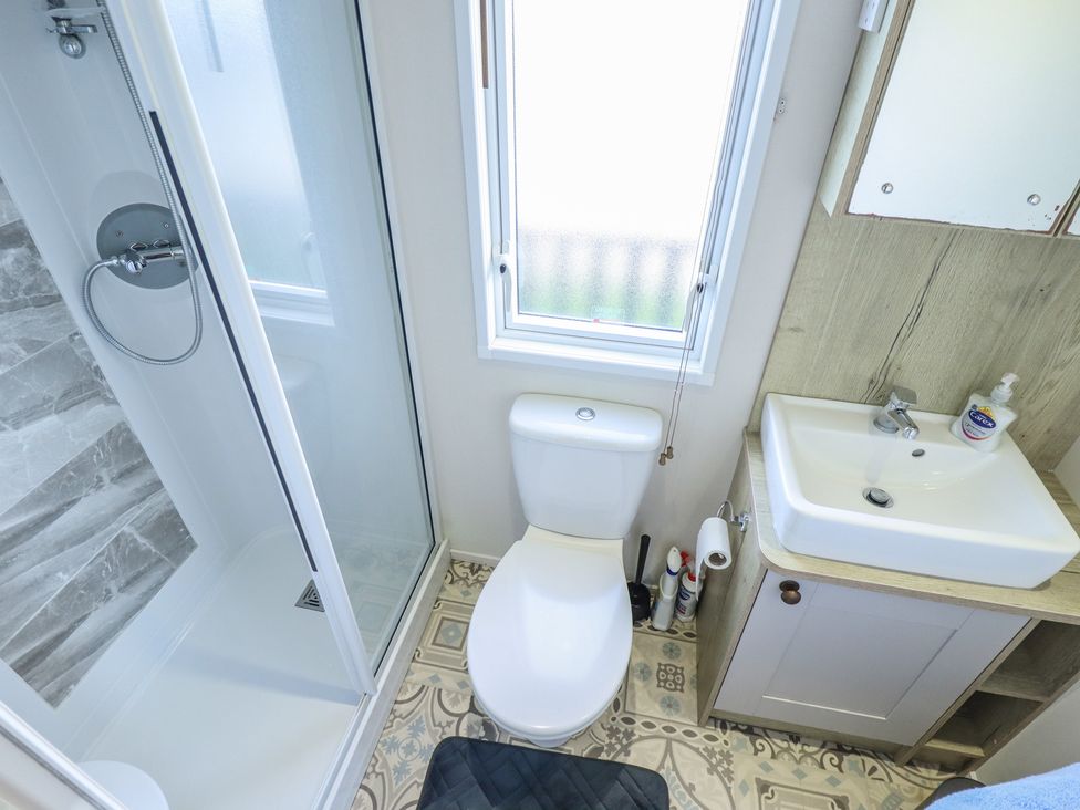 A bathroom with a shower, toilet, and sink at Number 6 - Sandy Beach Holiday Park, Bacton