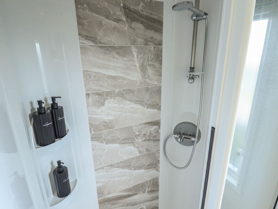 A shower with shampoo and conditioner at Number 6 - Sandy Beach Holiday Park in Bacton