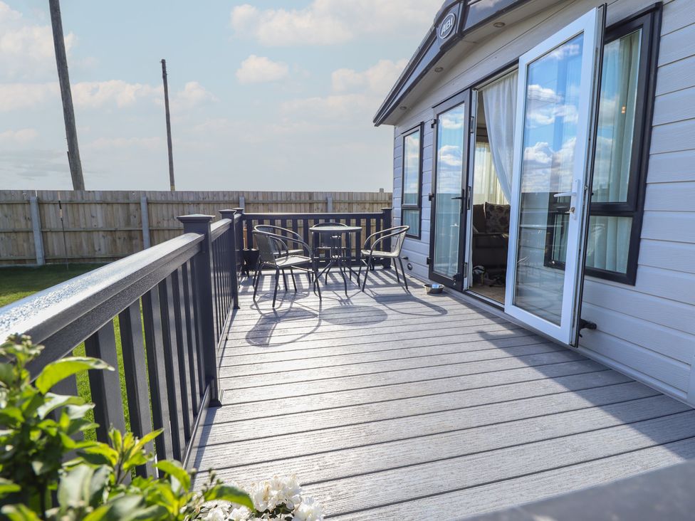 A decking area with a table and chairs at Number 6 - Sandy Beach Holiday Park Bacton