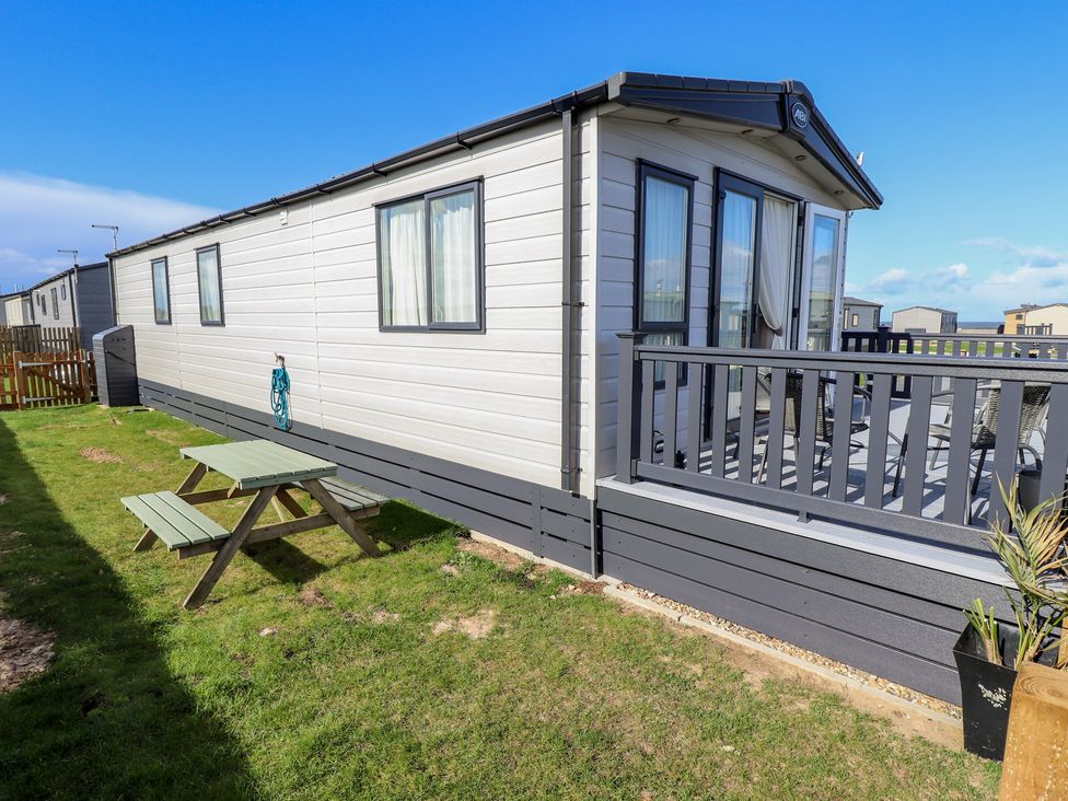 A caravan with a deck and a picnic table at Number 6 - Sandy Beach Holiday Park Bacton