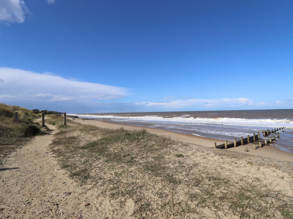 A beach with waves and a path at Number 6 - Sandy Beach Holiday Park in Bacton