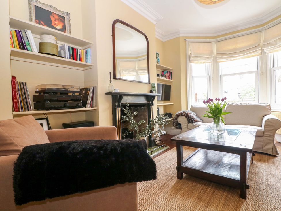 A living room with bookshelves and a sofa at Tickety-Boo in Broadstairs