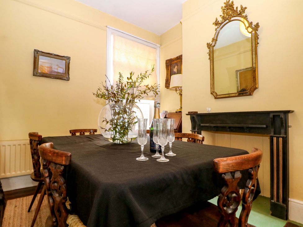 A dining room with a table set with glasses and flowers at Tickety-Boo in Broadstairs