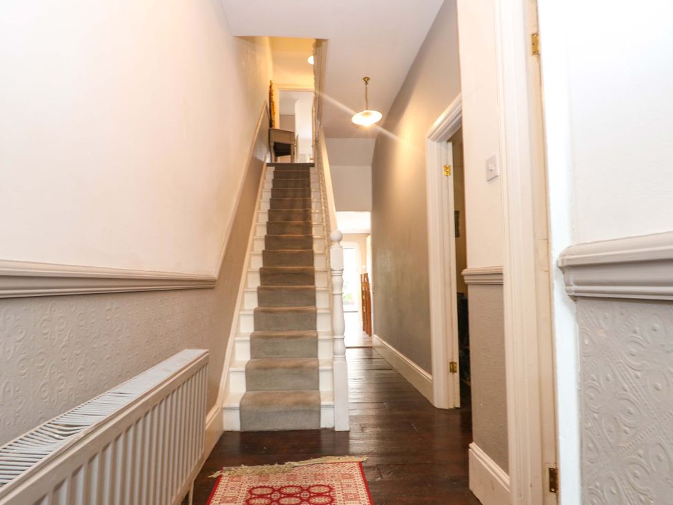 A hallway with a staircase and radiator at Tickety-Boo in Broadstairs
