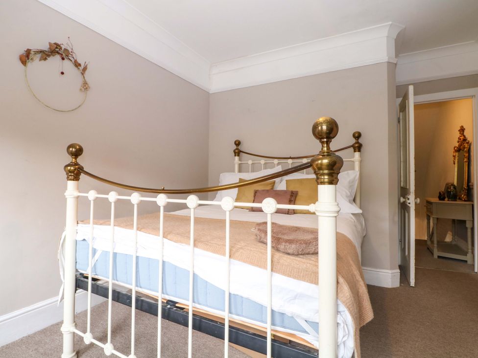 A bedroom with a bed and a mirror at Tickety-Boo in Broadstairs