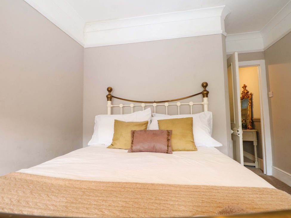 A bedroom with a bed and a mirror at Tickety-Boo in Broadstairs