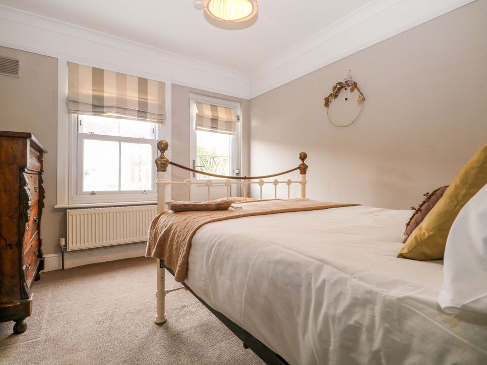 A bedroom with a bed and wooden dresser at Tickety-Boo in Broadstairs