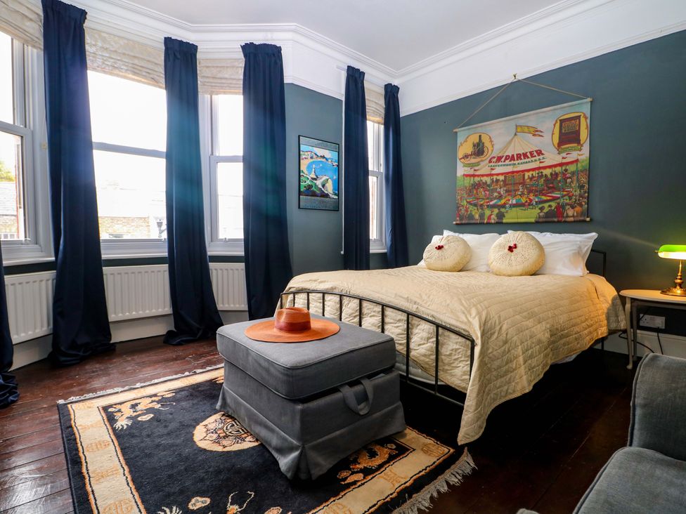 A bedroom with a bed and paintings at Tickety-Boo in Broadstairs