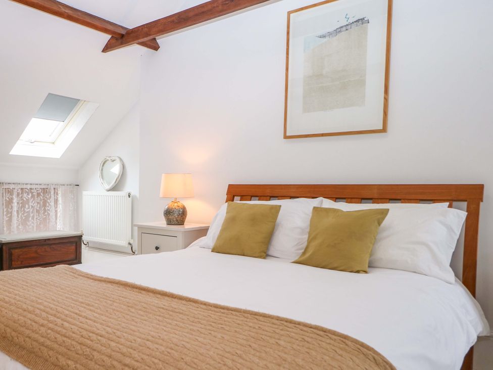 A bedroom with a bed, lamp, and window at Tickety-Boo in Broadstairs