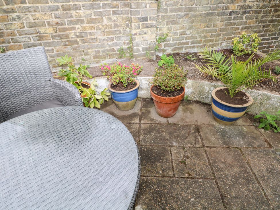 A garden with a table and chair alongside various plant pots at Tickety-Boo in Broadstairs