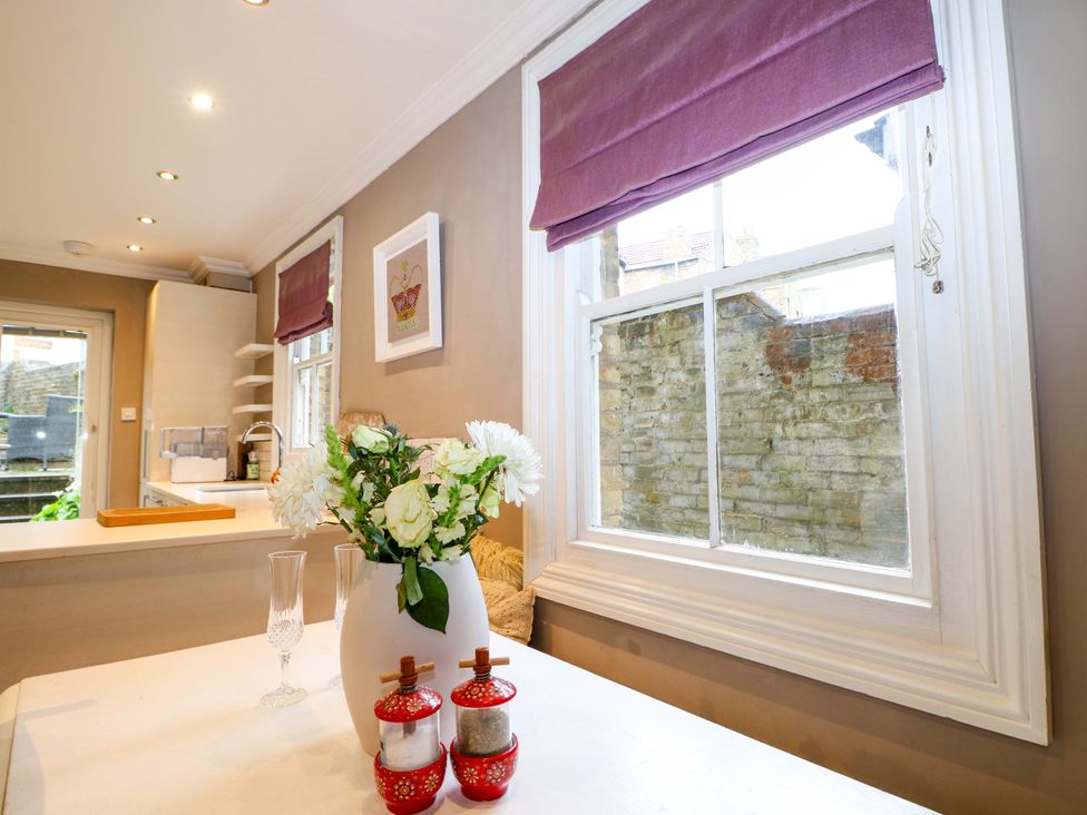 A kitchen with a window and flowers on the table at Tickety-Boo in Broadstairs