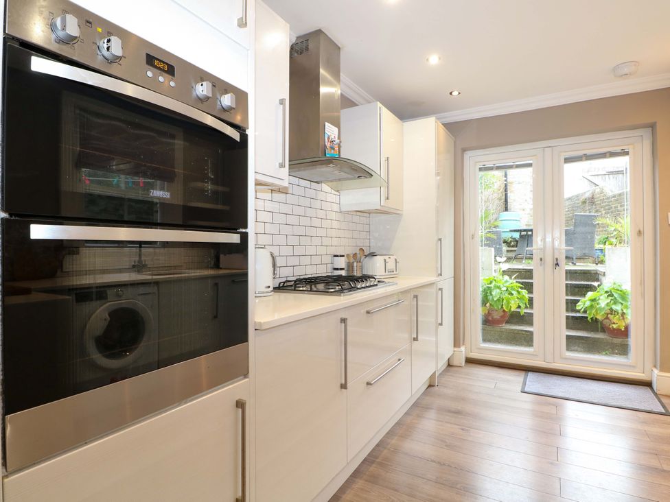 A kitchen with appliances and sliding doors leading to outdoor steps at Tickety-Boo in Broadstairs