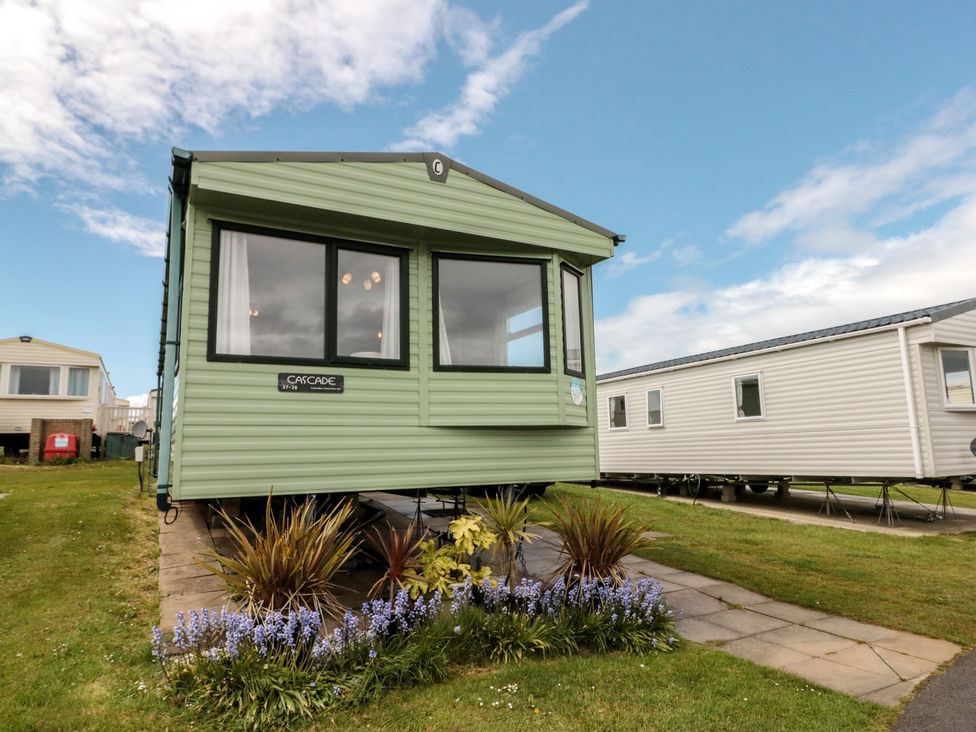 A mobile home with a flowerbed at 21 Dunlin Dell in Flamborough