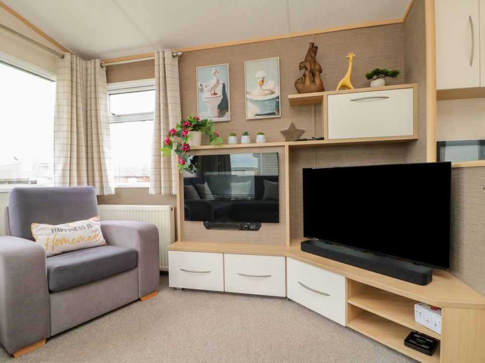 A living room with an armchair and television at 21 Dunlin Dell in Flamborough