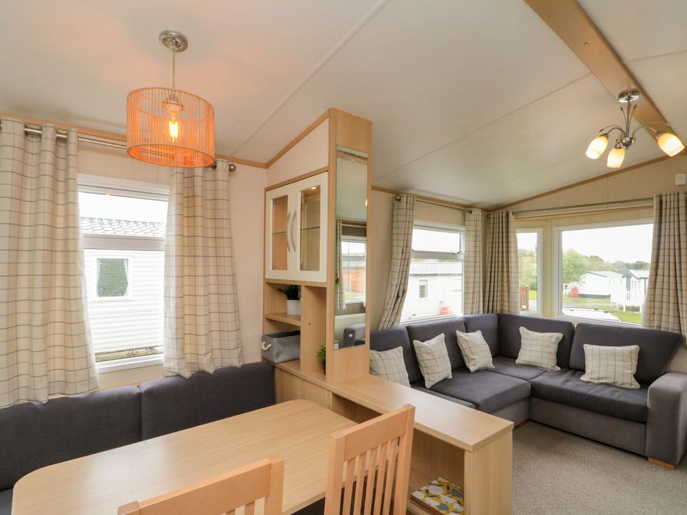 A living room with a sofa, dining table and chairs at 21 Dunlin Dell in Flamborough