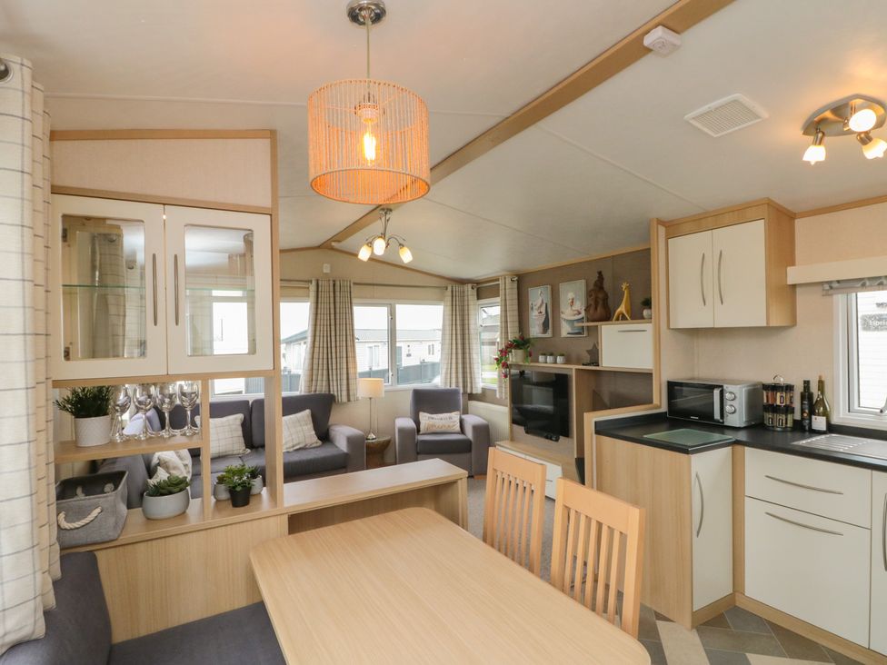 A living room with a table and sofa at 21 Dunlin Dell in Flamborough