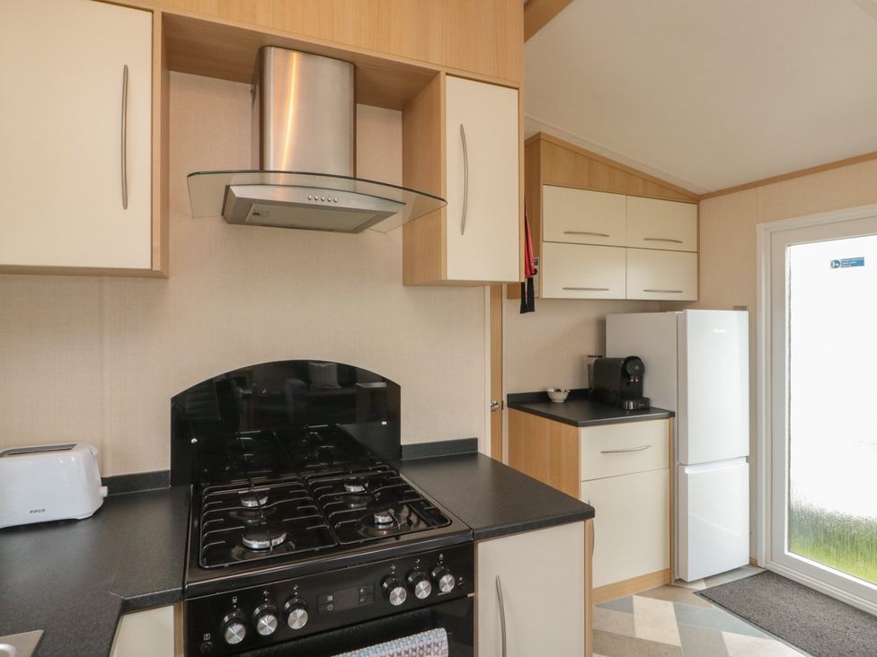 A kitchen with a gas stove, refrigerator and coffee machine at 21 Dunlin Dell in Flamborough