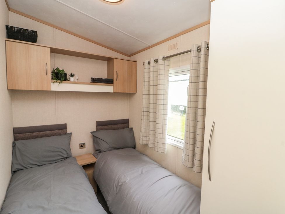 A bedroom with two beds and a window at 21 Dunlin Dell in Flamborough