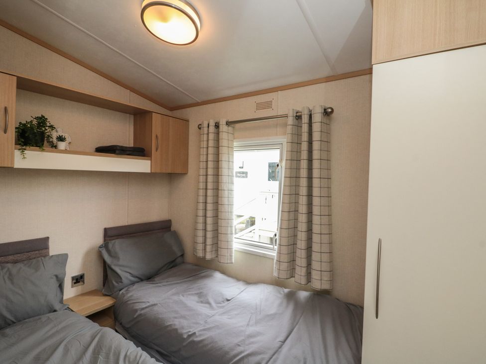 A bedroom with two beds and a window at 21 Dunlin Dell in Flamborough