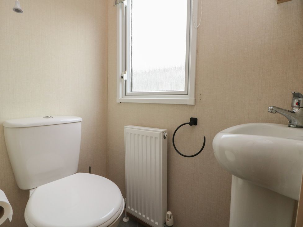 A bathroom with a toilet, sink, and radiator at 21 Dunlin Dell in Flamborough