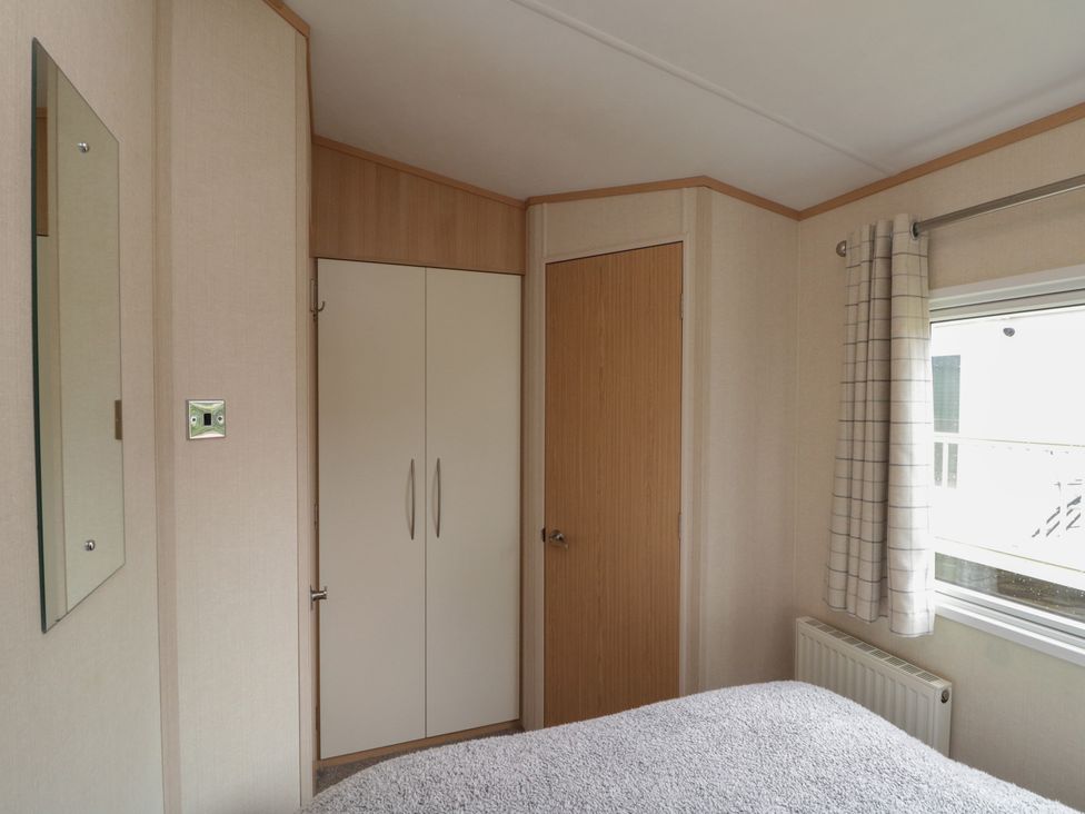 A bedroom with a bed and a wardrobe at 21 Dunlin Dell in Flamborough