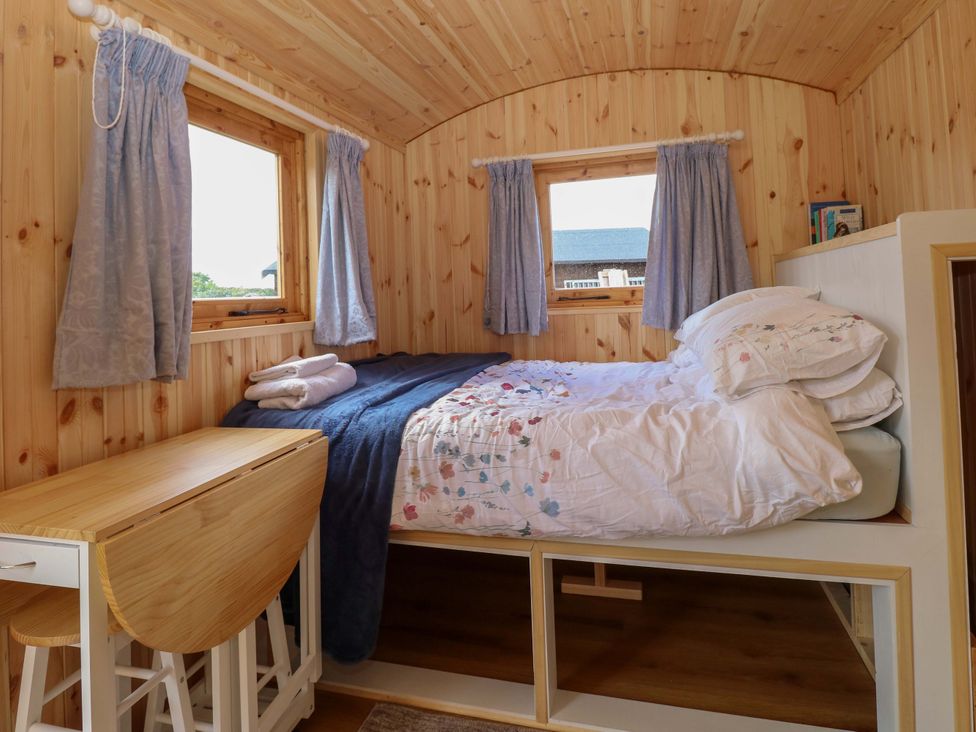 A bedroom with a bed and dining table in Hazel