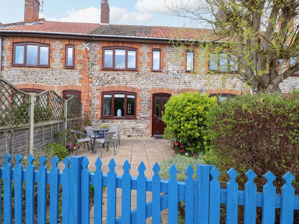 A garden with a blue fence and furniture at Old Summer in Northrepps near Cromer