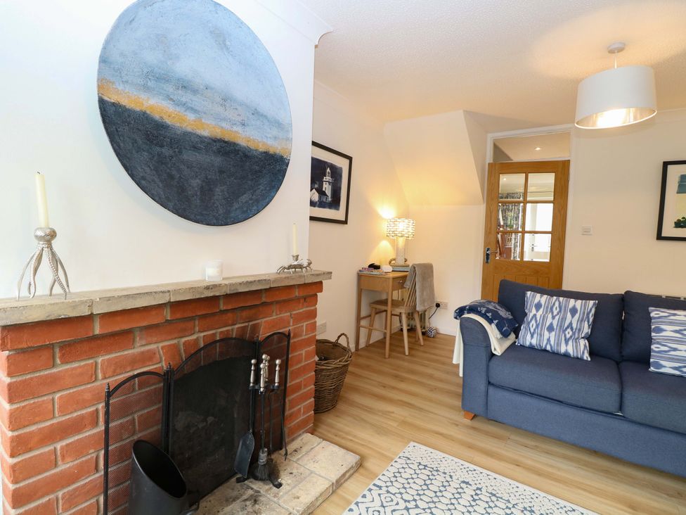 A living room with a fireplace and a sofa at Old Summer in Northrepps near Cromer