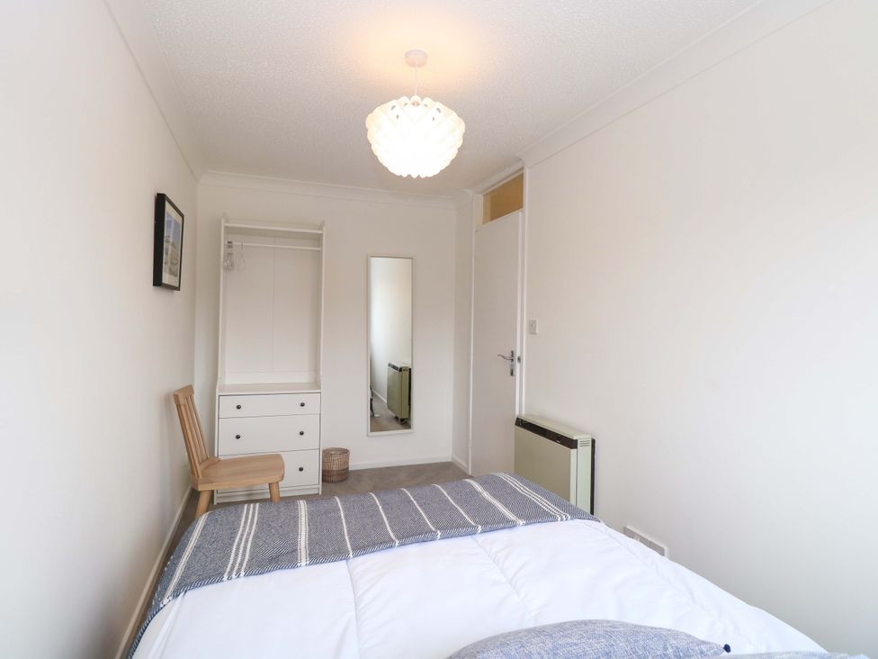 A bedroom with a bed and a mirror at Old Summer in Northrepps near Cromer