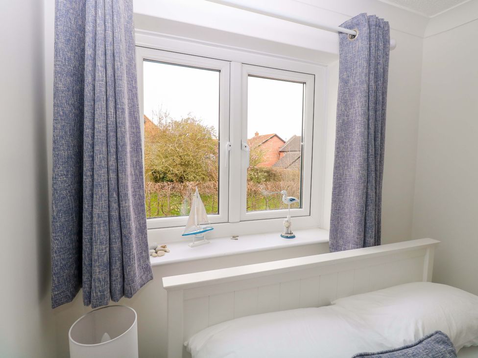 A bedroom with a window and decorative items at Old Summer Northrepps near Cromer