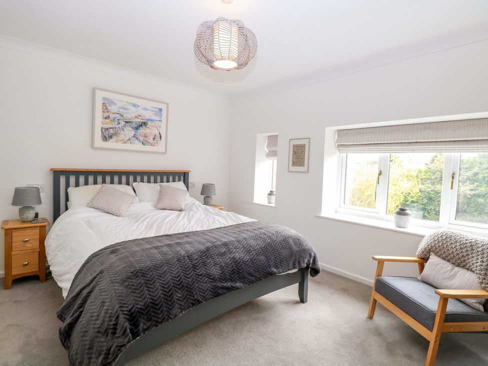 A bedroom with a bed and chair at Old Summer in Northrepps near Cromer