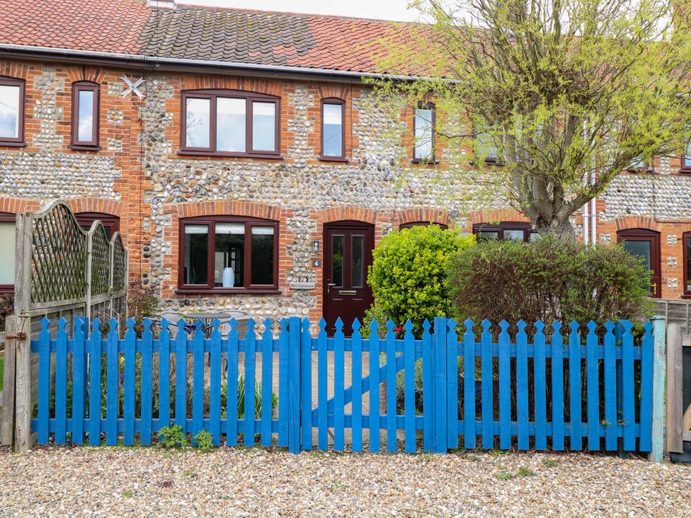 A house with a blue fence and shrubs at Old Summer Northrepps near Cromer