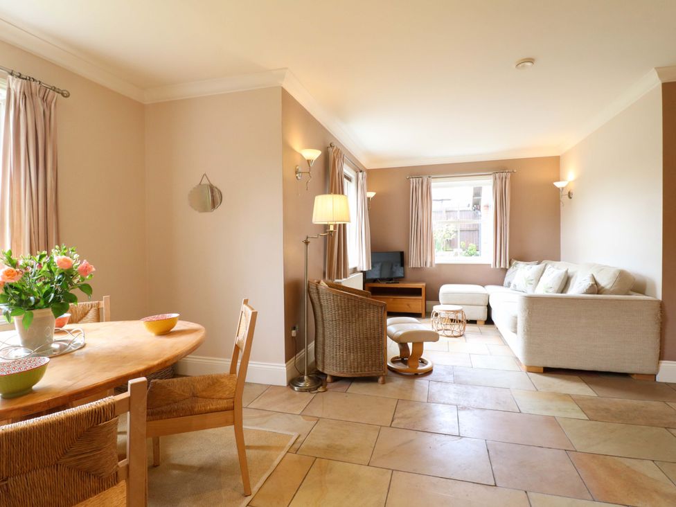 A living room with a sofa and dining area at The Garden House in Alton