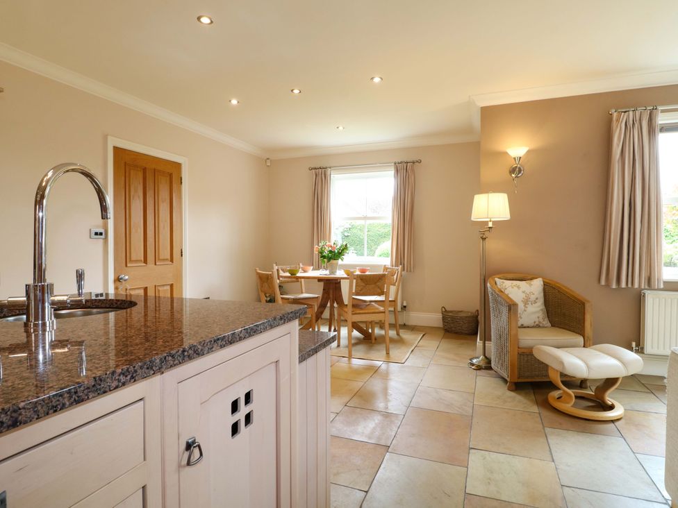 A kitchen with a dining area and a sofa at The Garden House in Alton