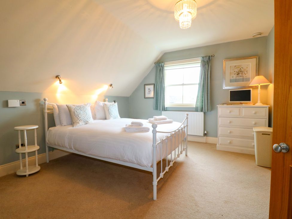 A bedroom with a bed and dresser at The Garden House in Alton