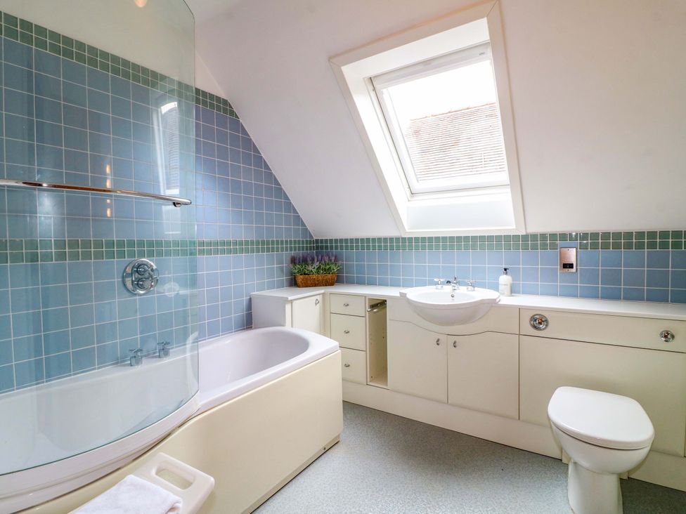 A bathroom with a bathtub, sink, toilet, and shower at The Garden House in Alton