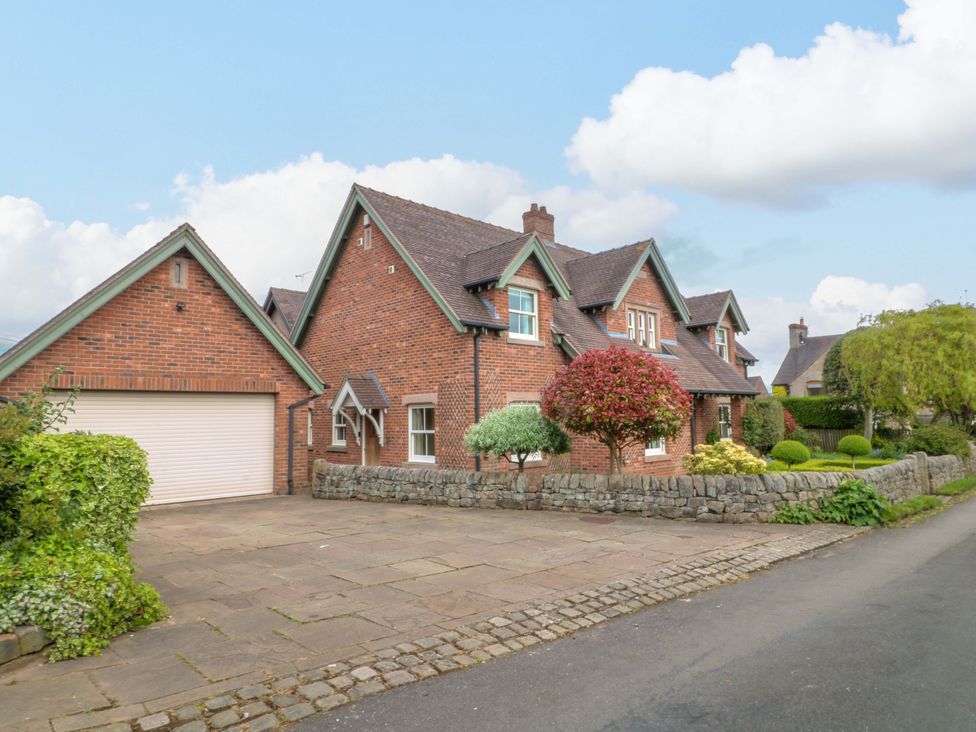A house with a driveway and garage at The Garden House in Alton